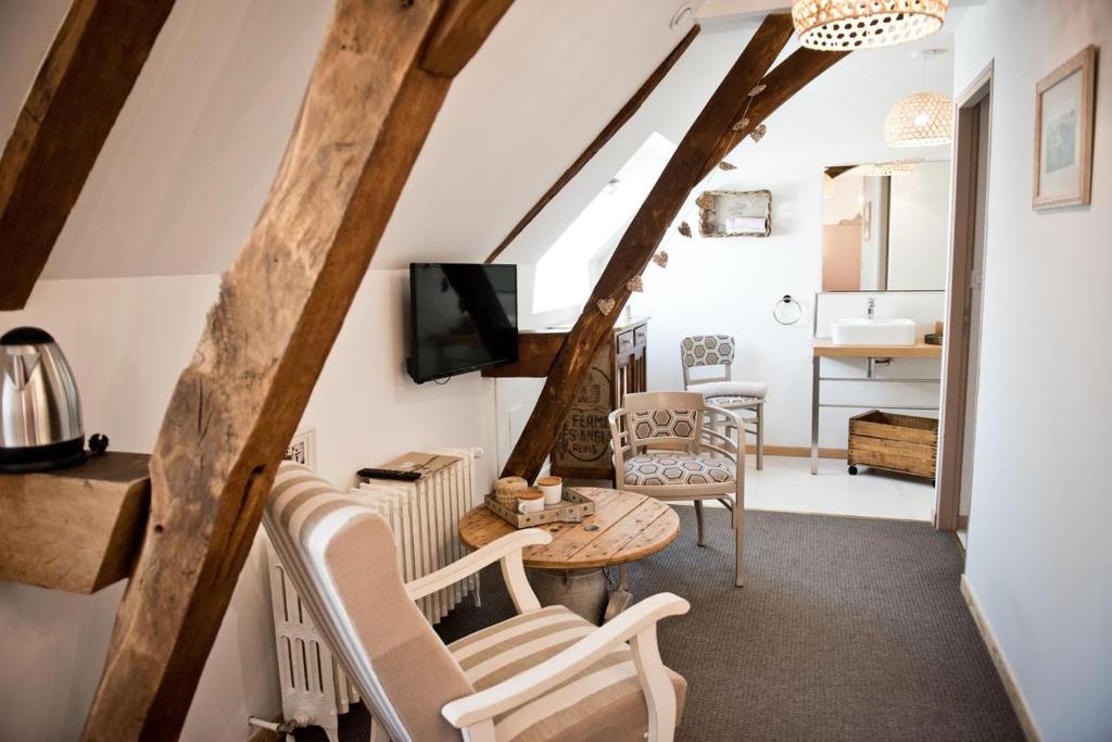 un salon avec une table et des chaises dans l'établissement Gîte La feuille d'Acanthe, à Bucilly