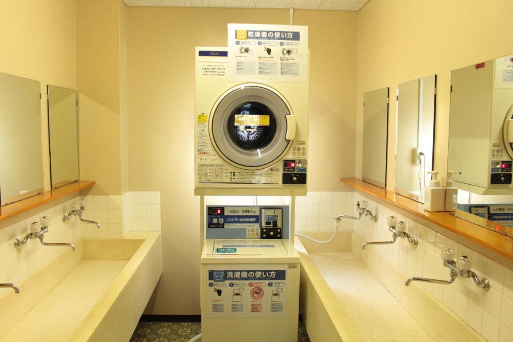 - un lave-linge dans la salle de bains pourvue de lavabos et de miroirs dans l'établissement Miyajima Seaside Hotel, à Miyajima