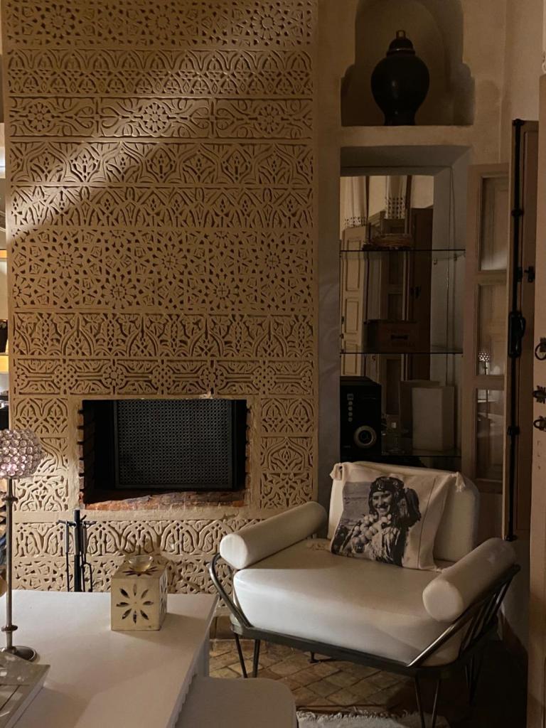 - un salon avec une chaise et une cheminée dans l'établissement Riad Les Orangers D'alilia, à Marrakech