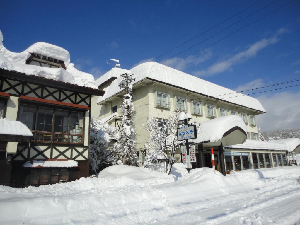 un bâtiment recouvert de neige avec un tas de neige dans l'établissement Lake Side Hotel Minatoya, à Inawashiro
