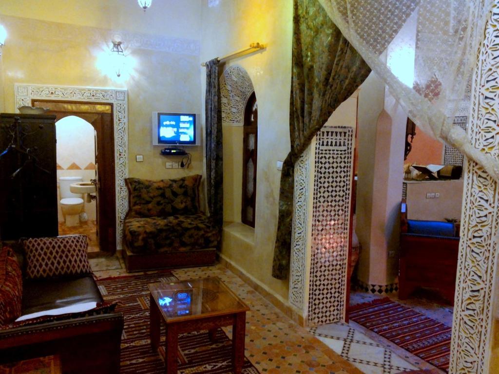 un salon avec un canapé et une table dans l'établissement Riad Benchekroun, à Meknès