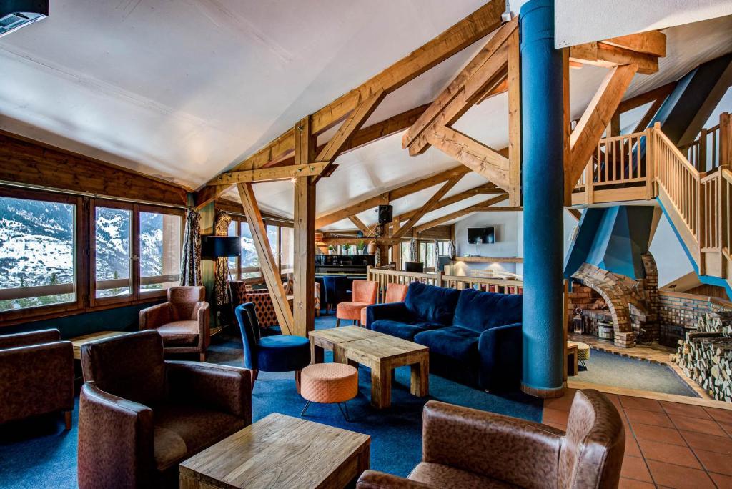 un salon avec un canapé et une table dans l'établissement Hôtel Le Montana, à La Tania
