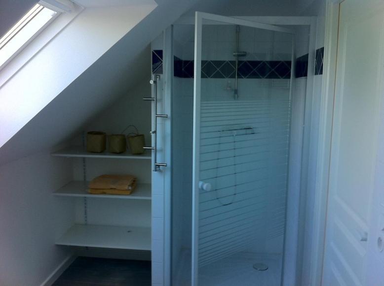 une salle de bain avec douche en verre dans un grenier dans l'établissement Au Beau Gîte, à Carentoir