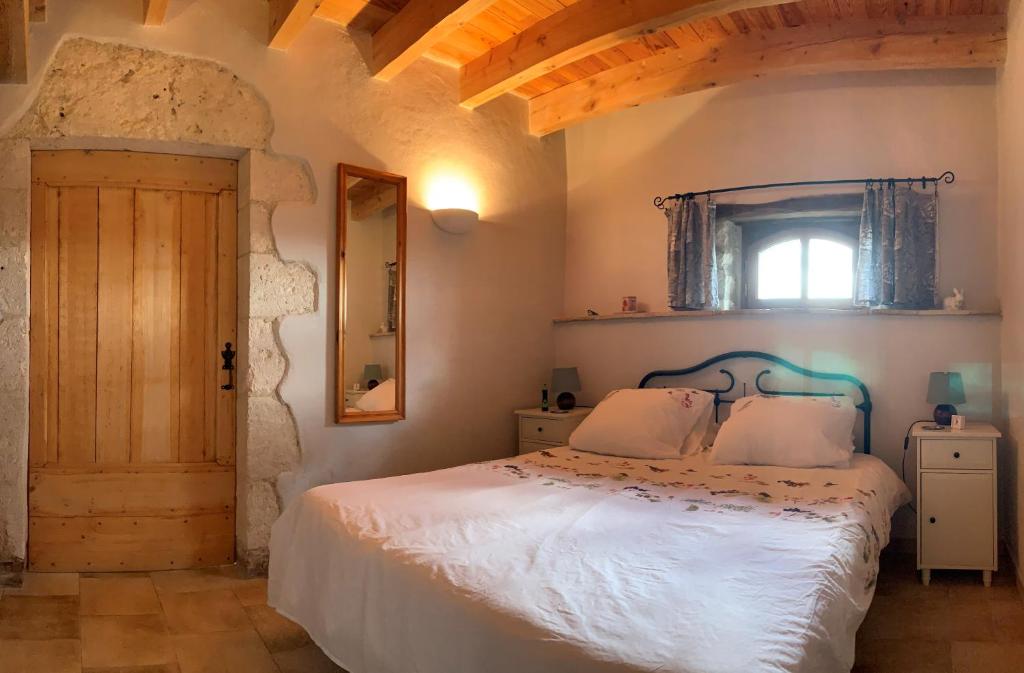 une chambre avec un lit blanc et une fenêtre dans l'établissement Gîte Le Pressoir, à Cahuzac-sur-Vère
