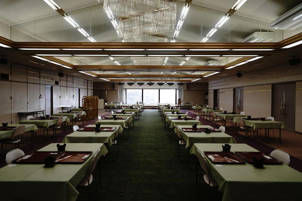 Cette grande chambre comprend des tables et des chaises vertes. dans l'établissement Mori no RyoTei Mount Bandai, à Inawashiro