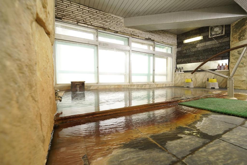 une pièce vide avec un sol imprégné d'eau et des fenêtres dans l'établissement Mori no RyoTei Mount Bandai, à Inawashiro