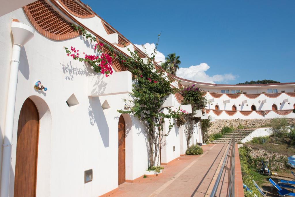 Un bâtiment blanc avec des fleurs sur le côté dans l'établissement Mon Rêve Resort, à Tarente