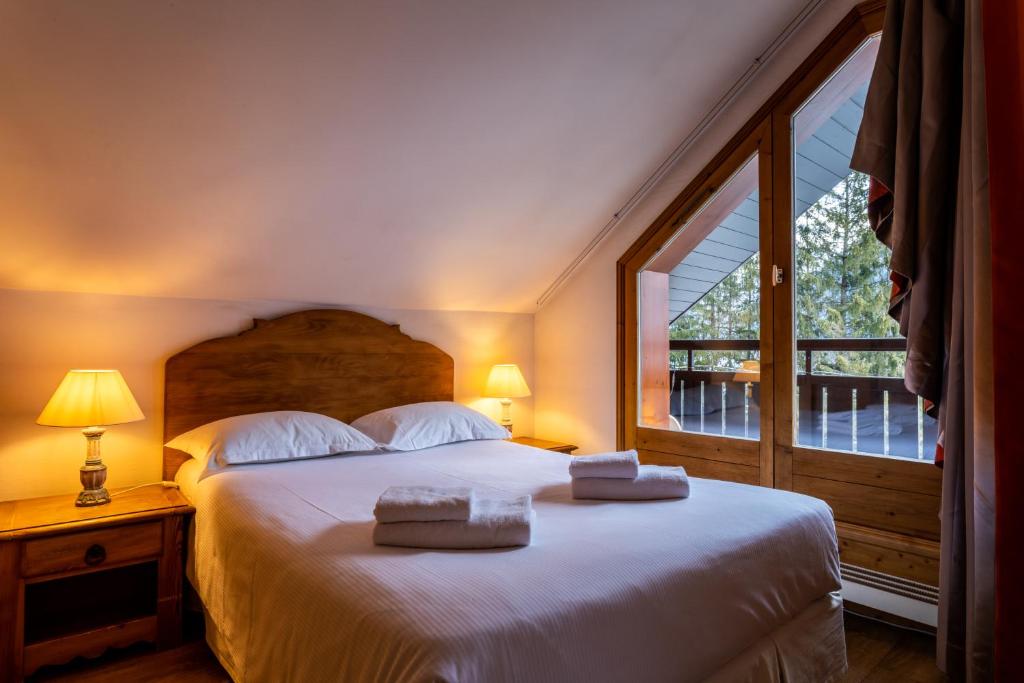 une chambre avec un grand lit avec des serviettes dessus dans l'établissement Les Balcons du Savoy, à Chamonix-Mont-Blanc