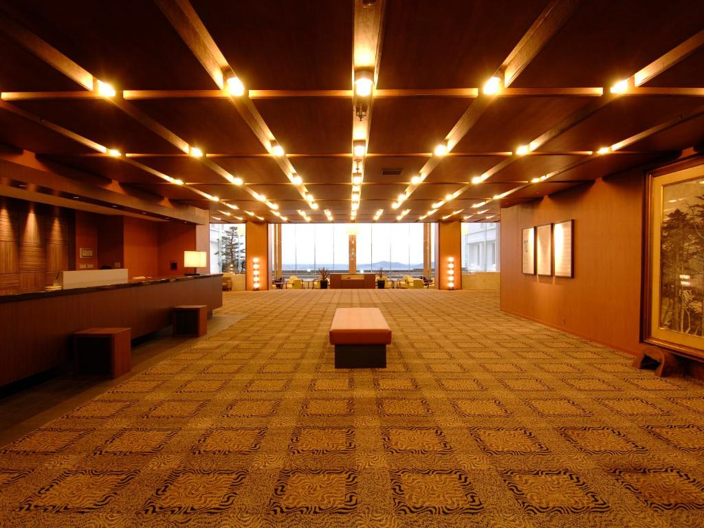 une grande chambre avec un banc au milieu dans l'établissement Gamagori Onsenkyo Mikawa Bay Hills Hotel, à Nishio