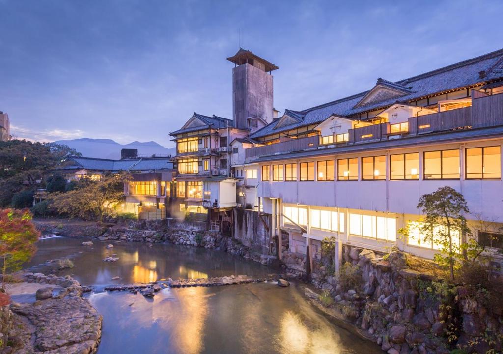 un bâtiment avec une rivière devant lui dans l'établissement Wataya Besso, à Ureshino
