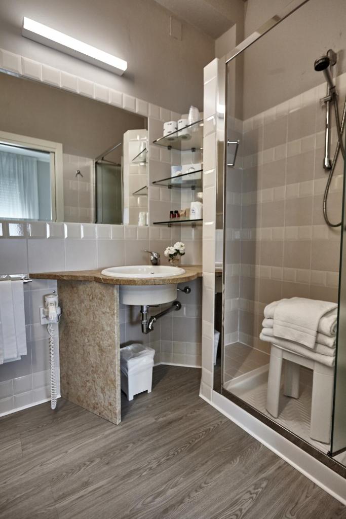 une salle de bain avec un lavabo et une douche dans l'établissement Rouge Hotel International, à Milano Marittima