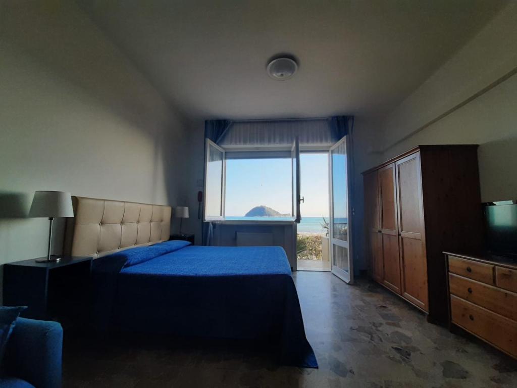 une chambre avec un lit bleu et une grande fenêtre dans l'établissement Residence Sole, à Albenga 110 autres photos