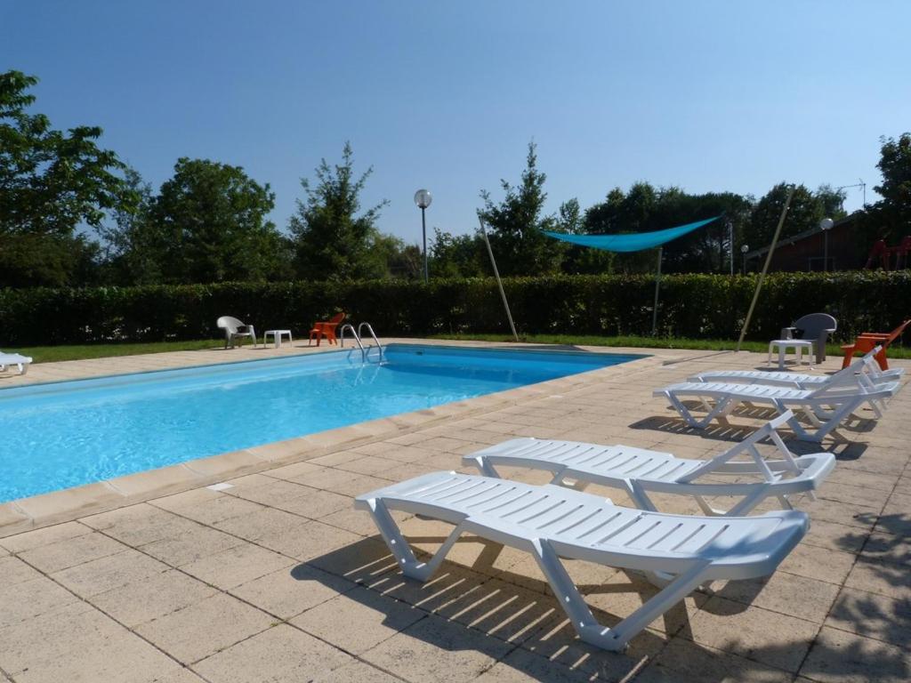 une piscine avec deux chaises longues à côté dans l'établissement Gites de la Garenne, à Nérac