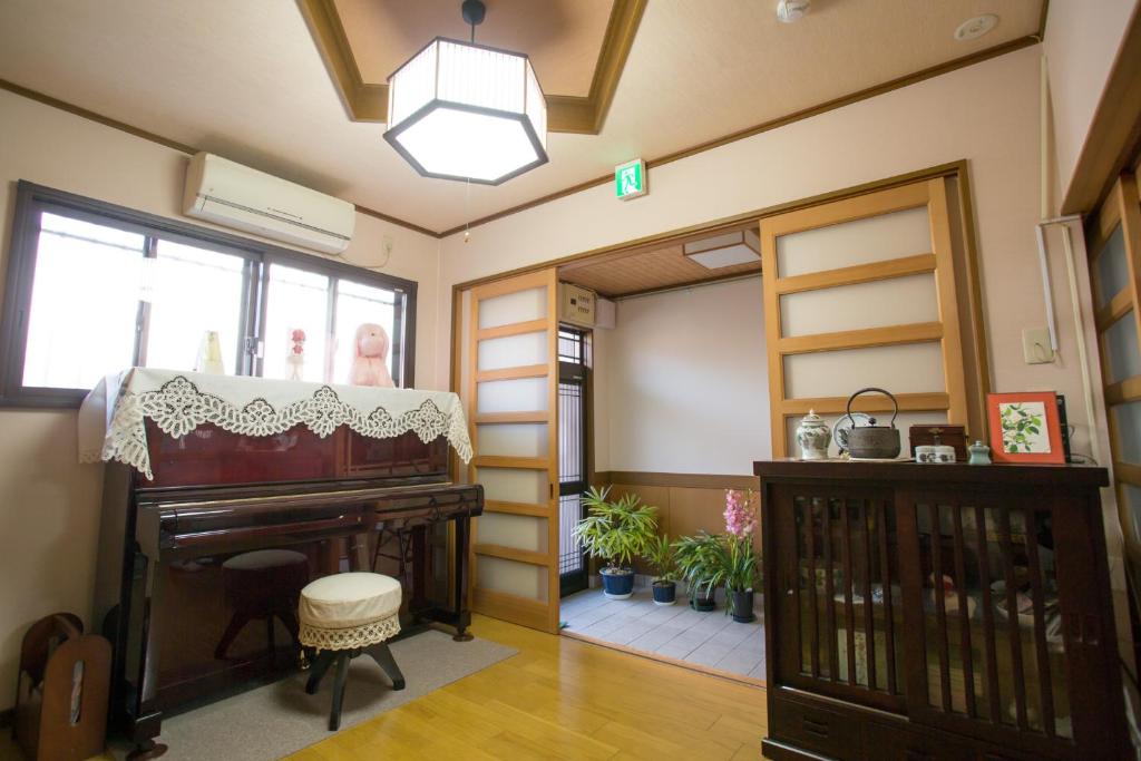 - un salon avec un piano et une fenêtre dans l'établissement Kyo Obataya, à Kyoto