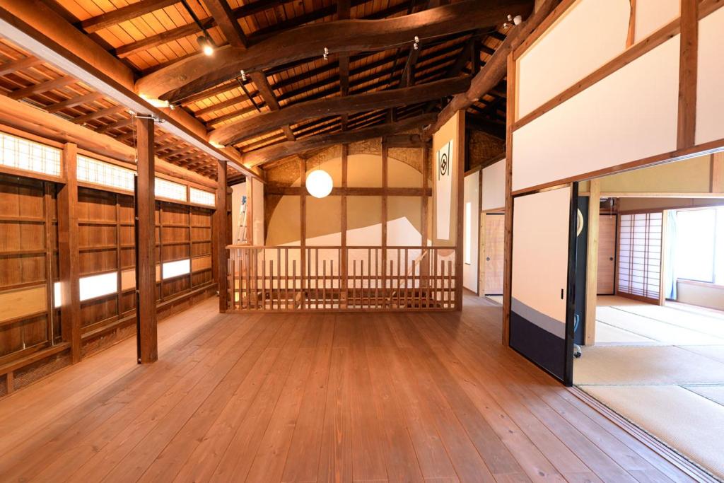 Cette grande chambre est dotée de parquet et d'un plafond en bois. dans l'établissement Mihokan, à Mihonosekichō