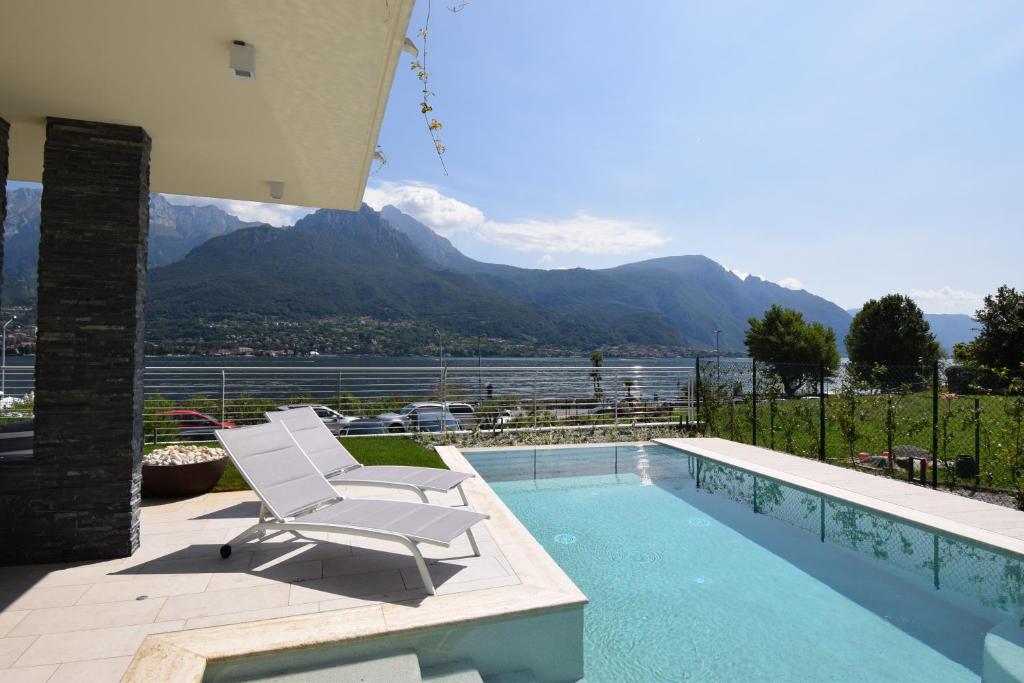 une chaise blanche assise à côté d'une piscine dans l'établissement Villa Mimosa Bellagio Wild Flowers, à Oliveto Lario