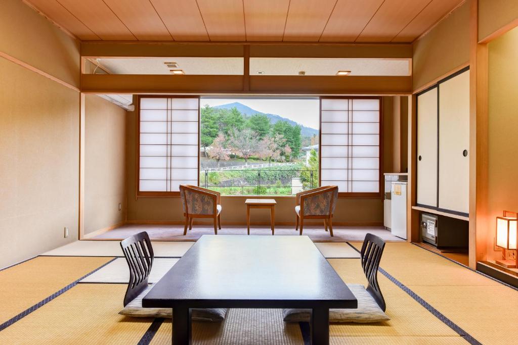 une salle à manger avec une table et des chaises et une grande fenêtre dans l'établissement Annex Fujiya Ryokan, à Kaminoyama