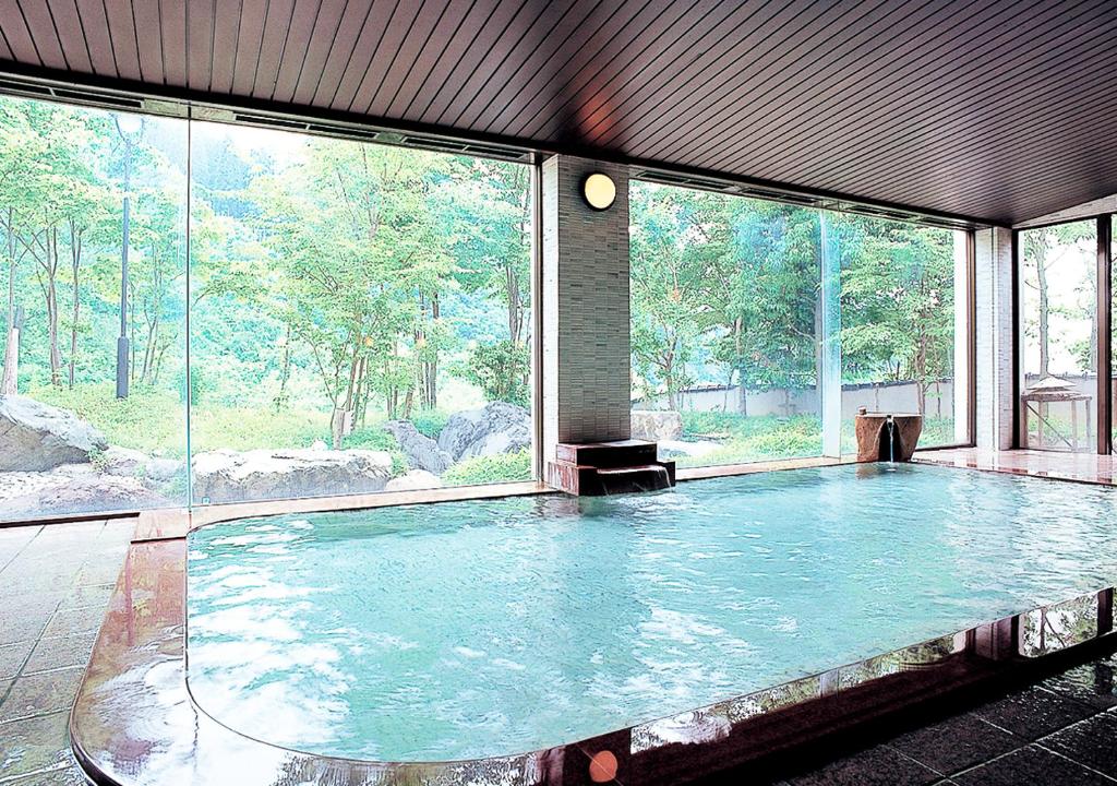 - une grande piscine d'eau dans une chambre avec fenêtres dans l'établissement Sasakura onsen Ryuunso, à Itoigawa 147 autres photos