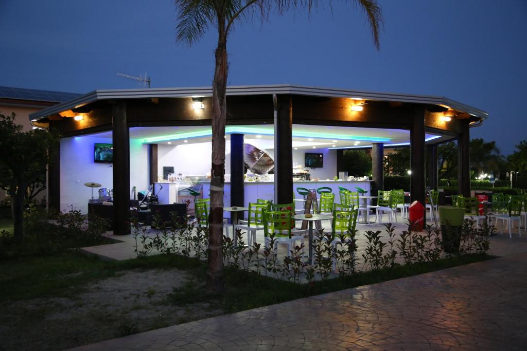 - un kiosque avec une table et des chaises la nuit dans l'établissement Club Esse Aquilia Beach Village, à Badolato