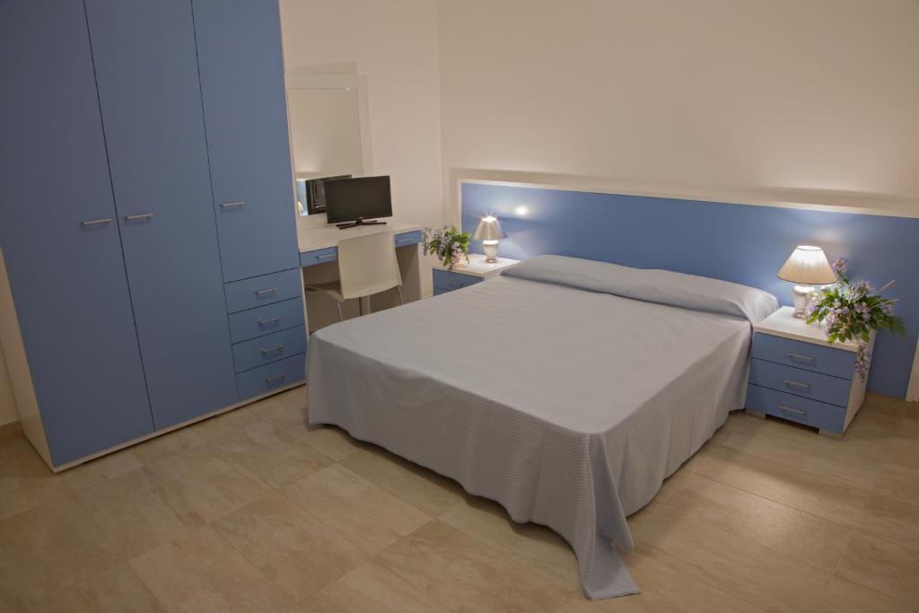 une chambre avec un lit, un bureau et une télévision dans l'établissement Club Esse Aquilia Beach Village, à Badolato