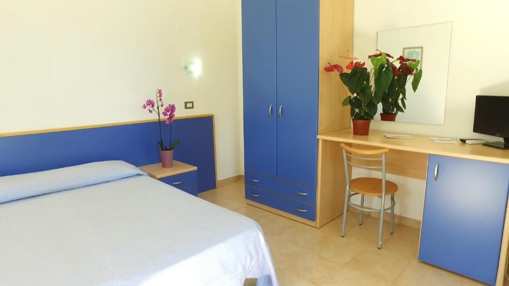 une chambre avec un lit et un bureau avec un ordinateur dans l'établissement Club Esse Aquilia Beach Village, à Badolato
