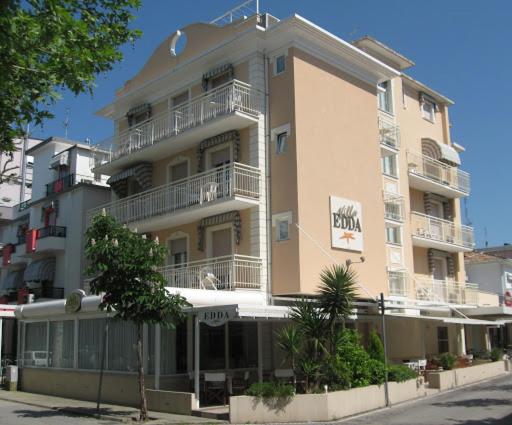 un grand bâtiment avec des balcons sur le côté d'une rue dans l'établissement Hotel Villa Edda, à Riccione