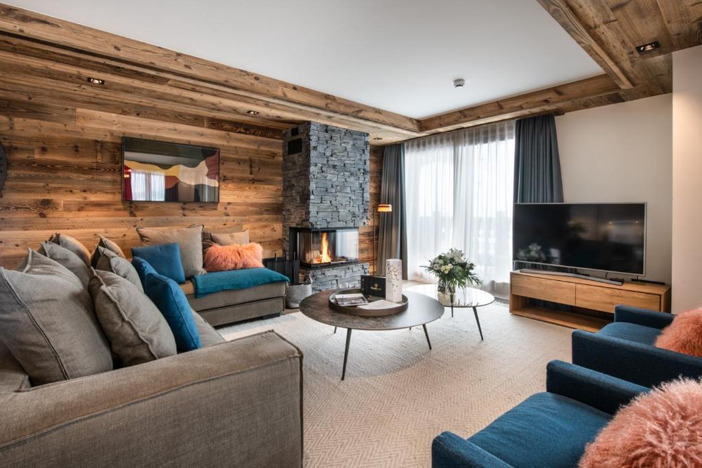 un salon avec un canapé et une télévision dans l'établissement Manali Lodge by Alpine Resorts, à Courchevel