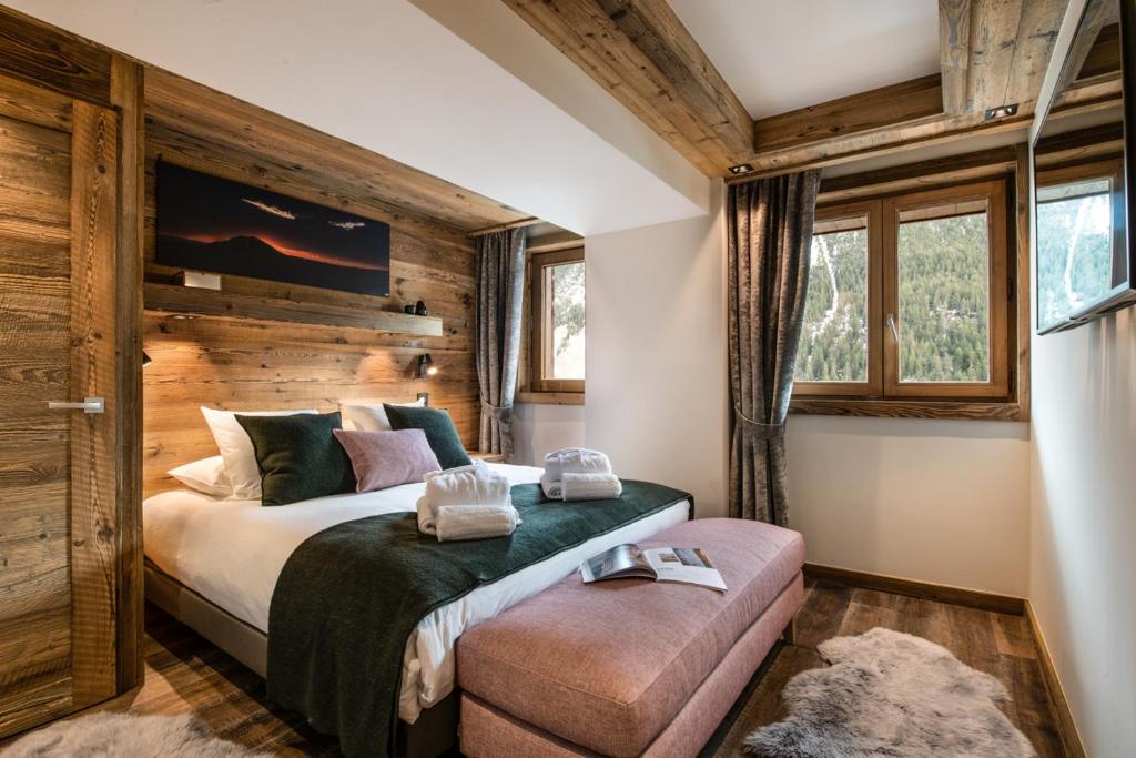 - une chambre avec un lit et un mur en bois dans l'établissement Manali Lodge by Alpine Resorts, à Courchevel 37 autres photos