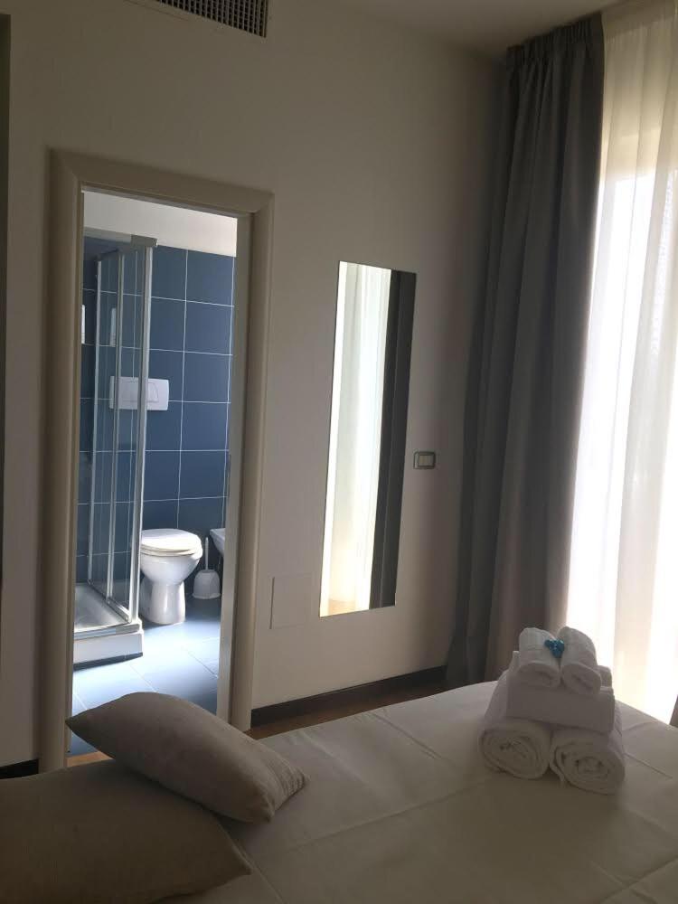 - une chambre avec un lit et 2 serviettes pliées dans l'établissement Hotel Royal, à San Benedetto del Tronto