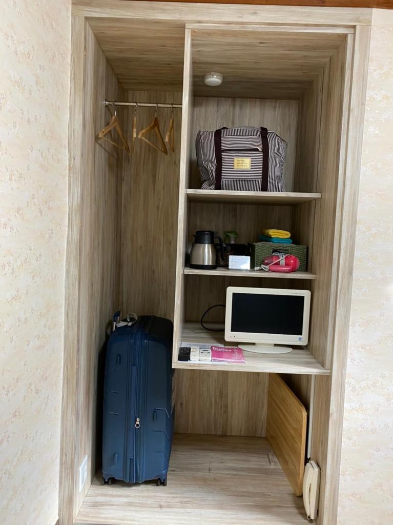 un bureau avec un ordinateur et une valise bleue dans l'établissement Asakusa Ryokan Toukaisou, à Tokyo