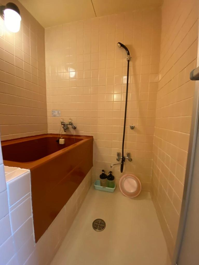 une salle de bain avec une baignoire, un lavabo et des toilettes dans l'établissement Asakusa Ryokan Toukaisou, à Tokyo