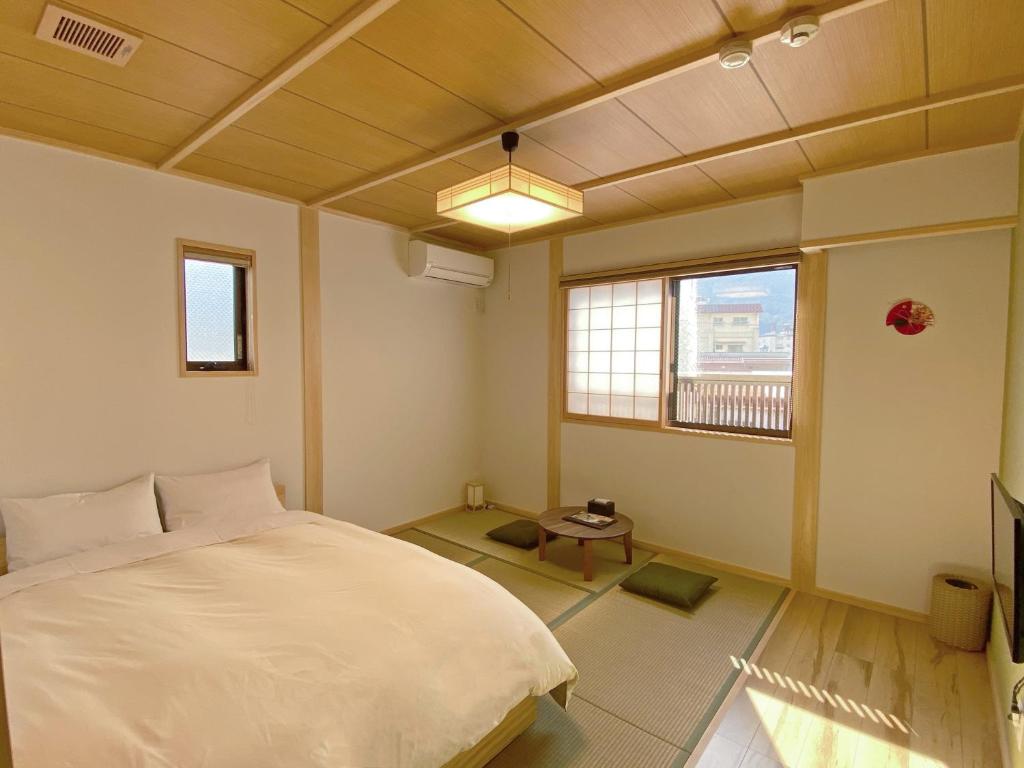 une chambre avec un lit blanc et une fenêtre dans l'établissement 寅家 Japanese modern hotel, à Gero