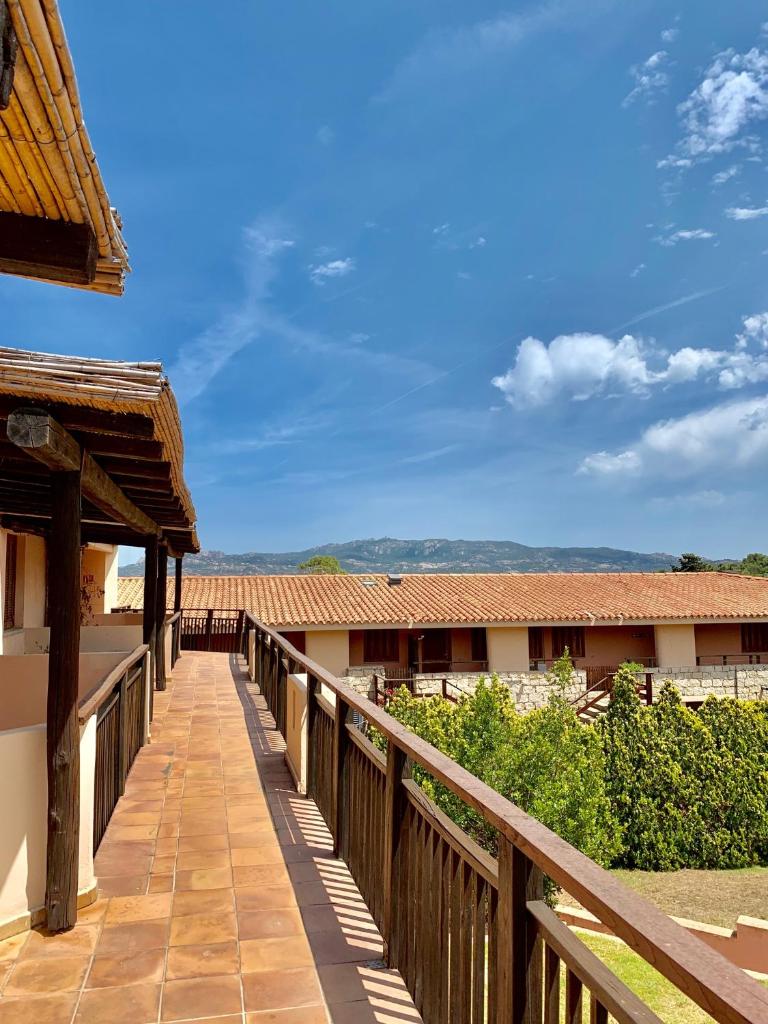 une passerelle en bois menant à un bâtiment dans l'établissement Swadeshi Sporting Hotel Tanca Manna, à Cannigione