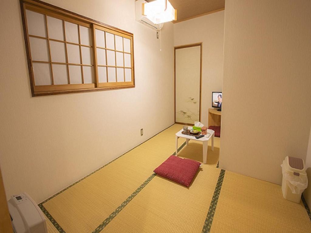 une chambre avec un lit, une table et une fenêtre dans l'établissement 金剛寺 宿坊 成穂院, à Matsukawa
