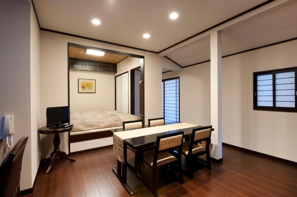 Cette chambre comprend une table, un lit et un miroir. dans l'établissement Hinode Ryokan, à Ise 29 autres photos