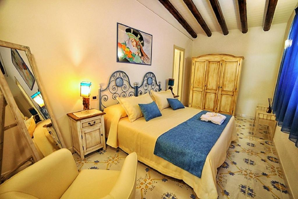 - une chambre avec un lit et deux chaises dans l'établissement Dimora A' Turri di GN Real Escapes, à Ribera