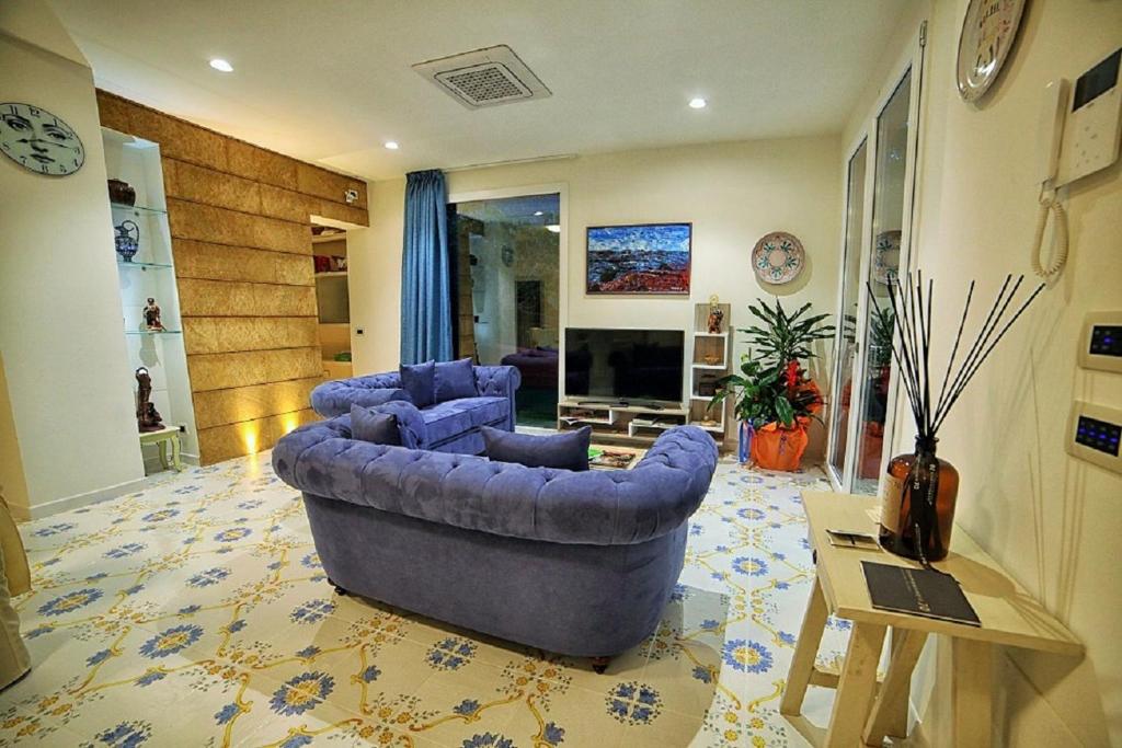 - un salon avec deux canapés bleus et une cheminée dans l'établissement Dimora A' Turri di GN Real Escapes, à Ribera