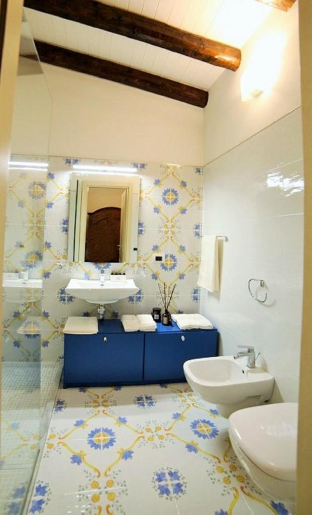 une salle de bain avec un lavabo et des toilettes dans l'établissement Dimora A' Turri di GN Real Escapes, à Ribera