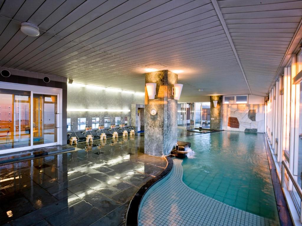 - une grande piscine dans un bâtiment avec piscine dans l'établissement Gamagori Onsenkyo Mikawa Bay Hills Hotel, à Nishio