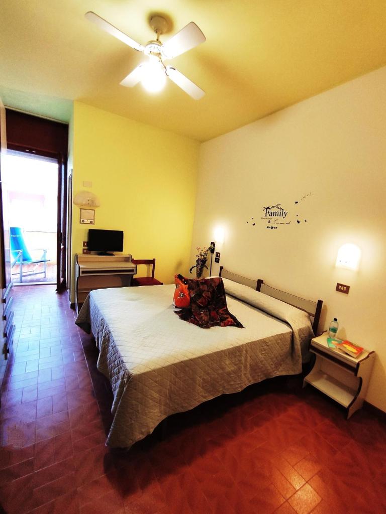 - une chambre avec un lit, un ventilateur de plafond et un piano dans l'établissement Hotel Palazzi, à Gabicce Mare