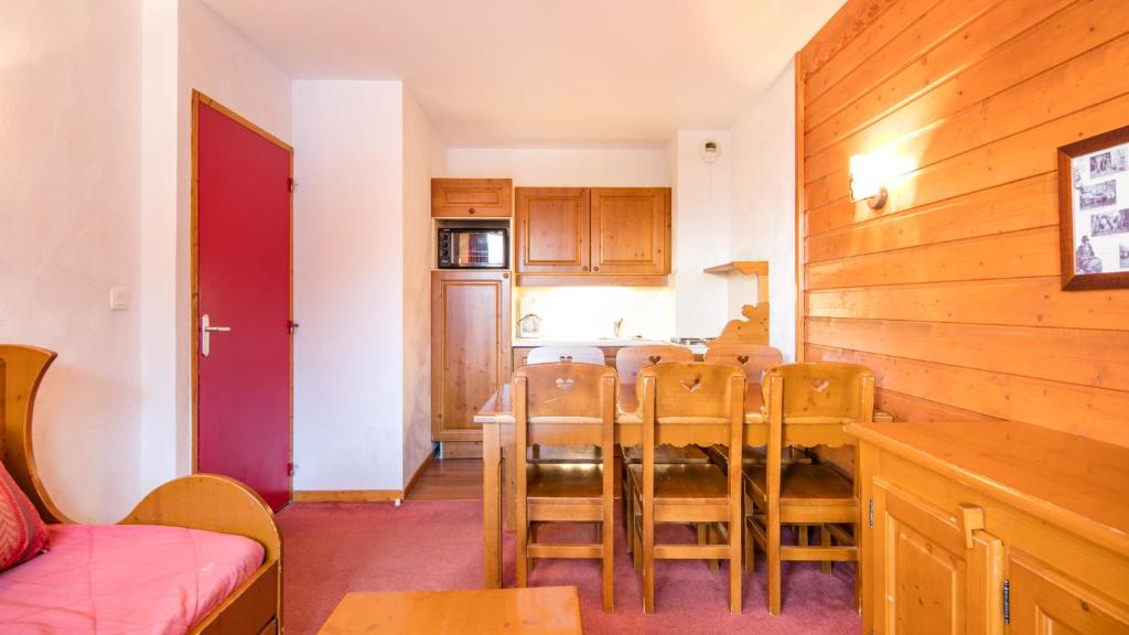 une cuisine et une salle à manger avec une table et des chaises dans l'établissement Vacancéole - Résidence La Turra, à Valfréjus