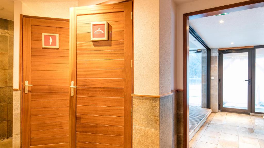 - une porte en bois dans une chambre avec fenêtre dans l'établissement Vacancéole - Résidence La Turra, à Valfréjus 25 autres photos