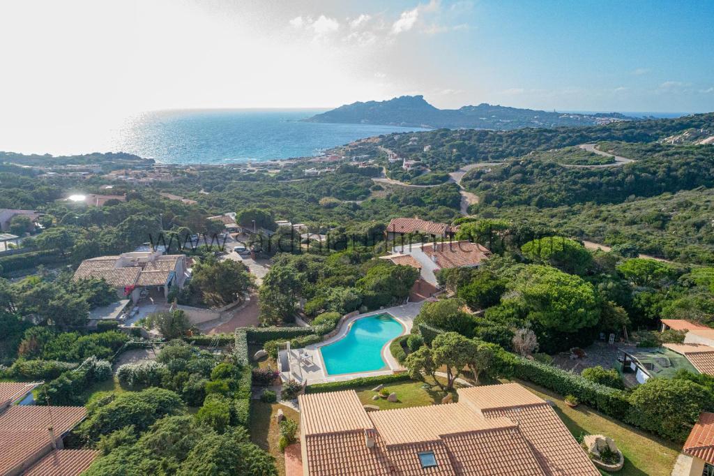 une vue aérienne d'un complexe hôtelier avec piscine et l'océan dans l'établissement Villa Incanto di Gallura, à Buoncammino