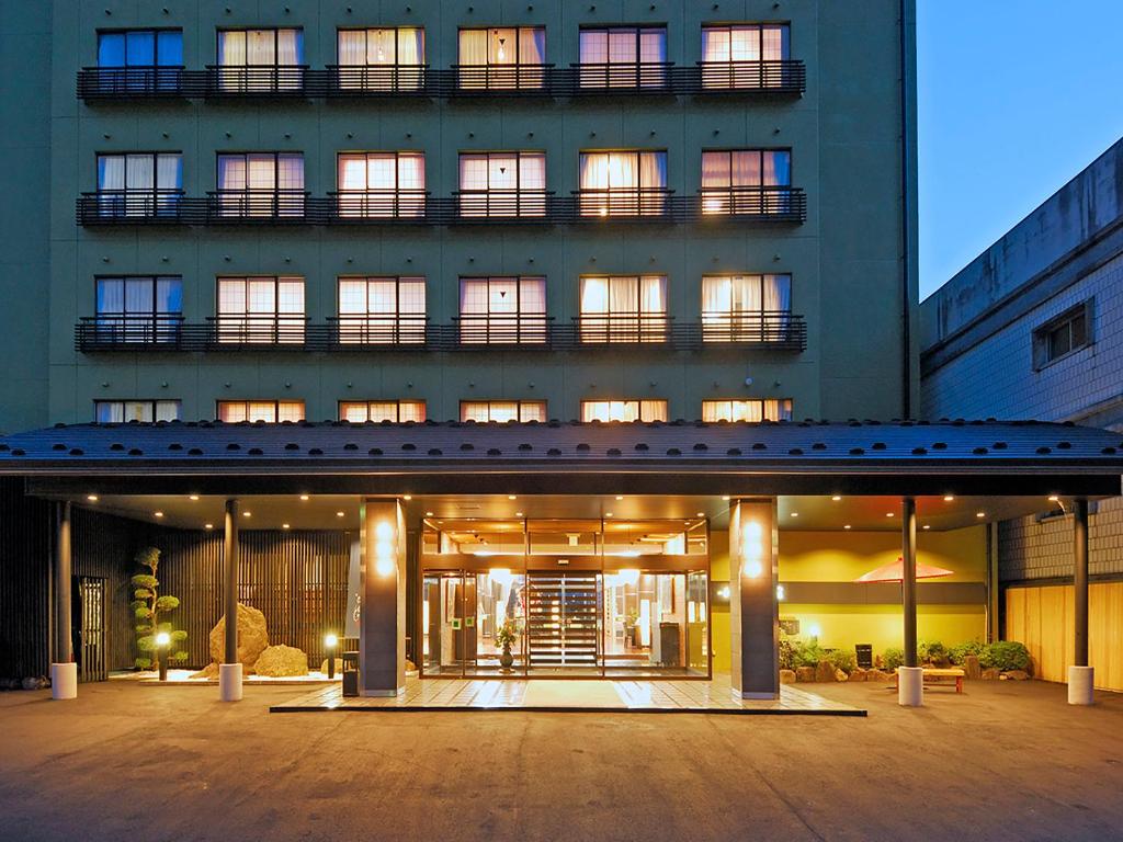 un grand bâtiment avec une cour en face dans l'établissement Ryokan Biyunoyado, à Yamanouchi
