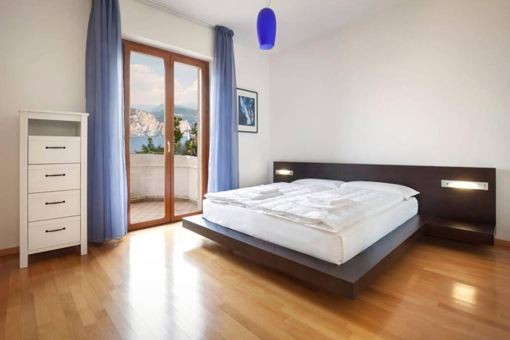 une chambre avec un grand lit et une grande fenêtre dans l'établissement Villa Mimosa-Con piscina e vista lago, à Brenzone 67 autres photos
