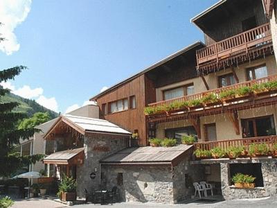 un grand bâtiment avec des plantes sur ses balcons dans l'établissement Chalet-Hôtel Alpage & SPA, à Vars