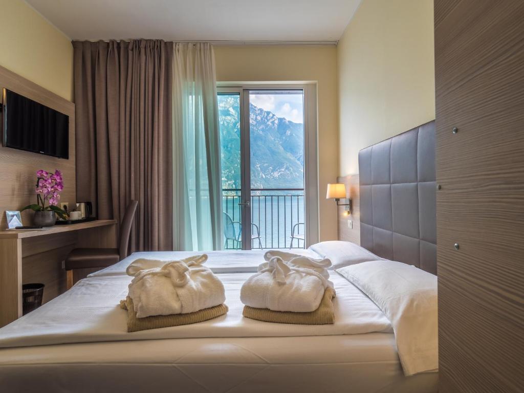 une chambre d'hôtel avec un lit avec des serviettes dessus dans l'établissement Hotel Capo Reamol, à Limone sul Garda