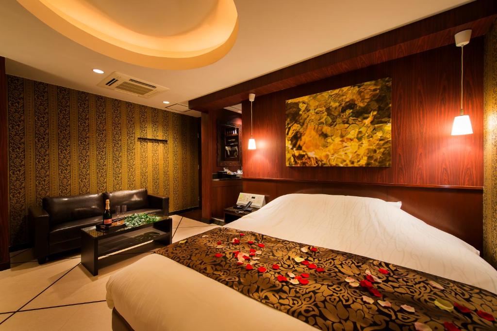 une chambre d'hôtel avec un lit et un canapé dans l'établissement Hotel CUE Machida(Adult Only), à Machida