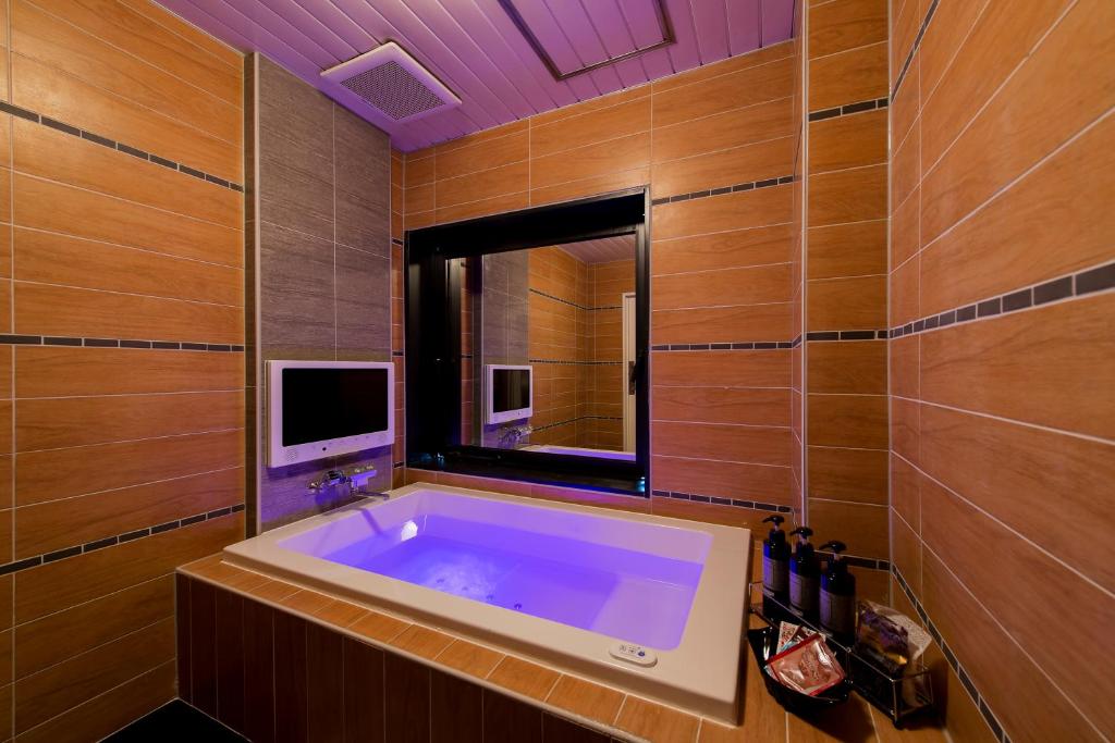 La salle de bains est pourvue d'une grande baignoire et d'une télévision. dans l'établissement Hotel CUE Machida(Adult Only), à Machida