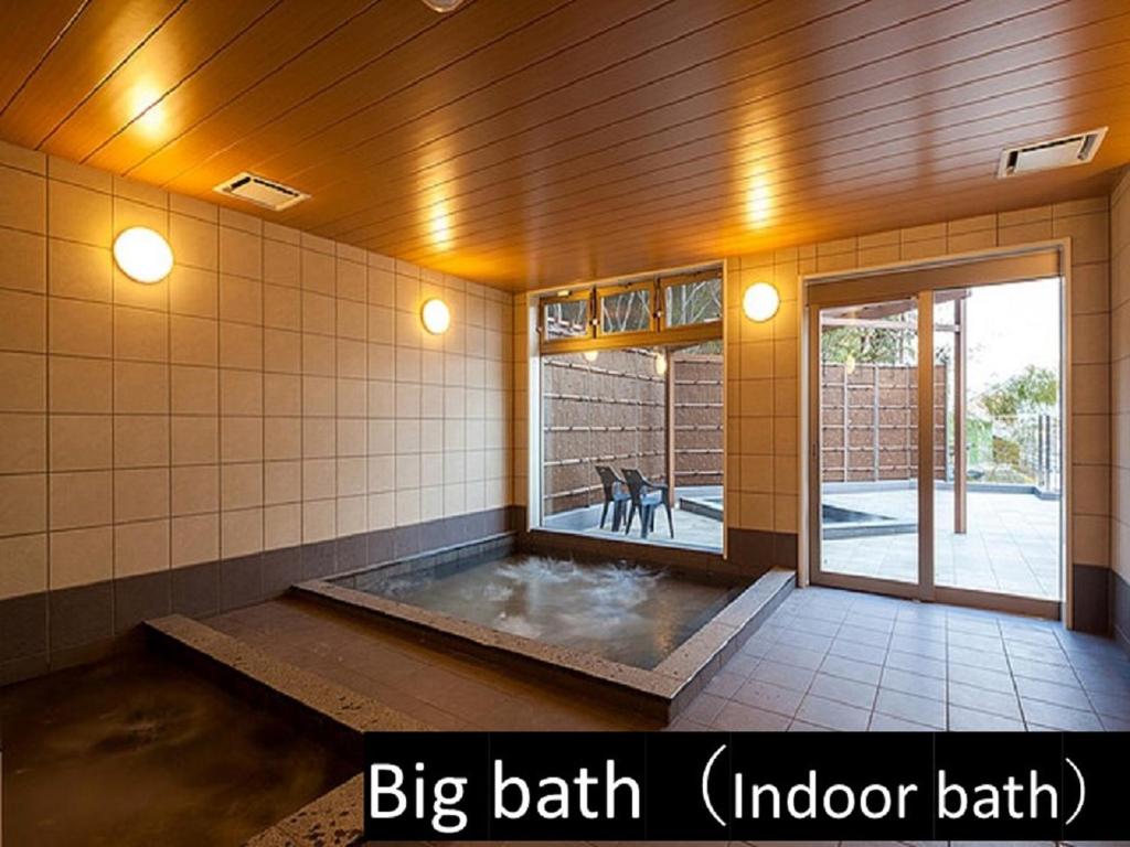 une grande chambre avec baignoire au milieu d'un bâtiment dans l'établissement Ryokan with natural hot springs and okonomiyaki Miyajima-an Hiroshima, à Miyajima